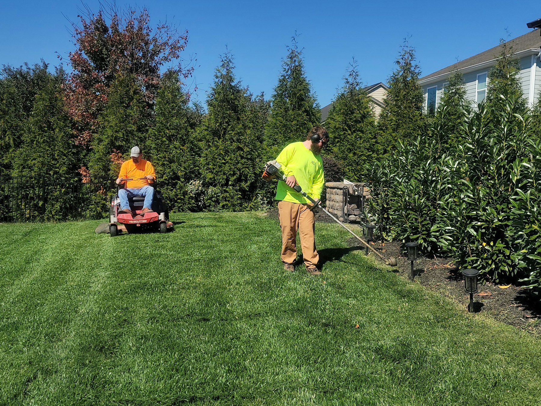 Landscaper mowing a lawn