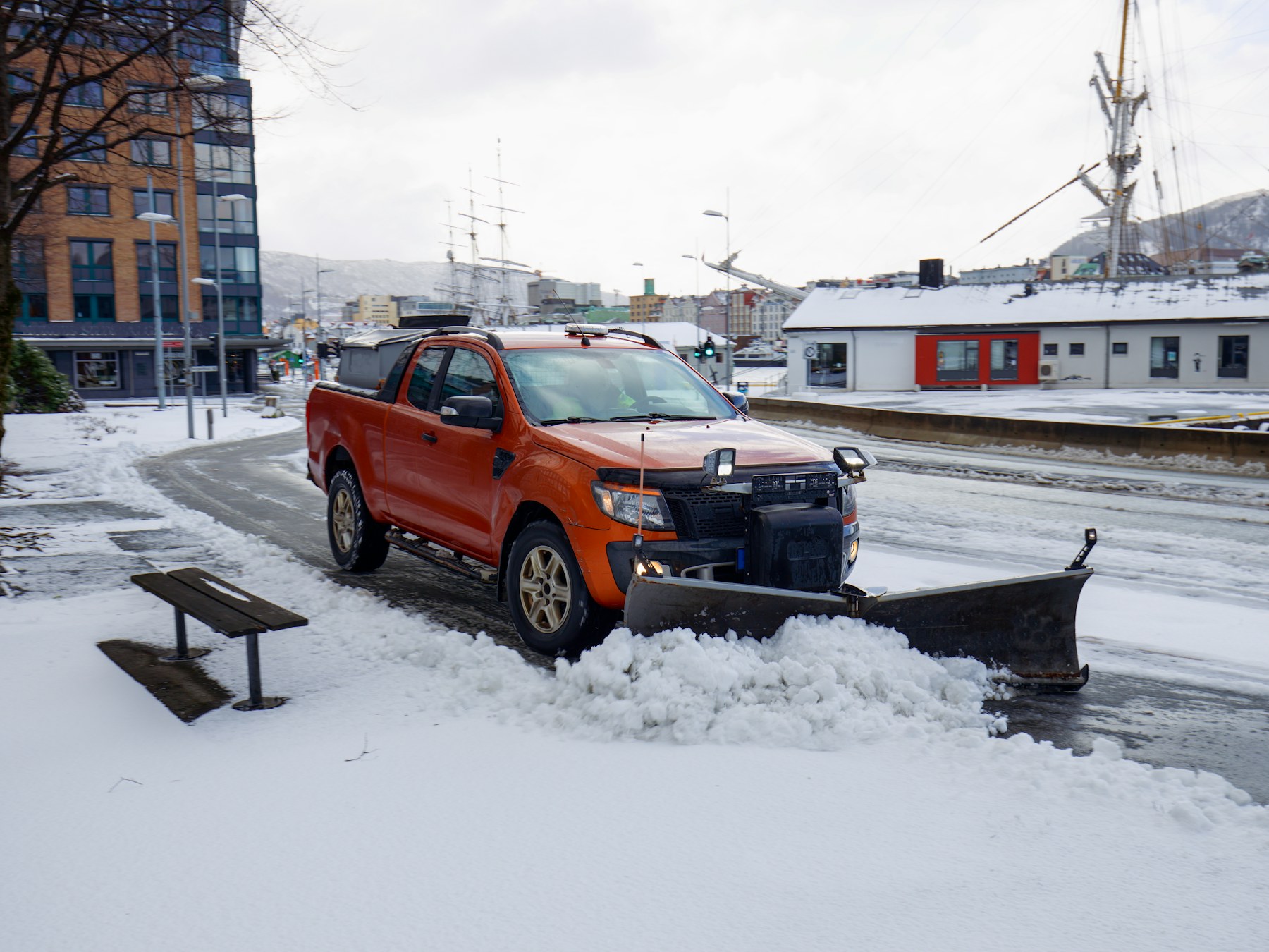 Snow plow parked on the side of a snowy road